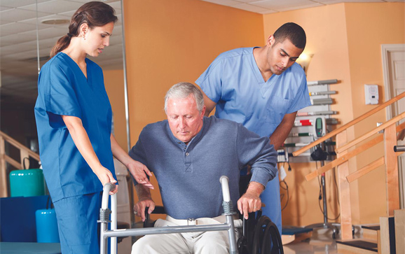 Healthcare workers with senior man in wheelchair